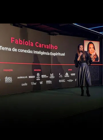 Fabíola Carvalho no palco, com o tema da palestra no telão