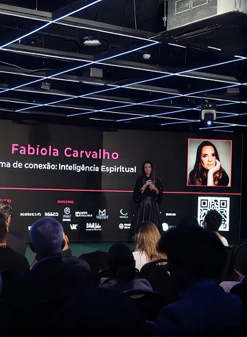 Plateia assistindo a um evento corporativo sob luzes azuis